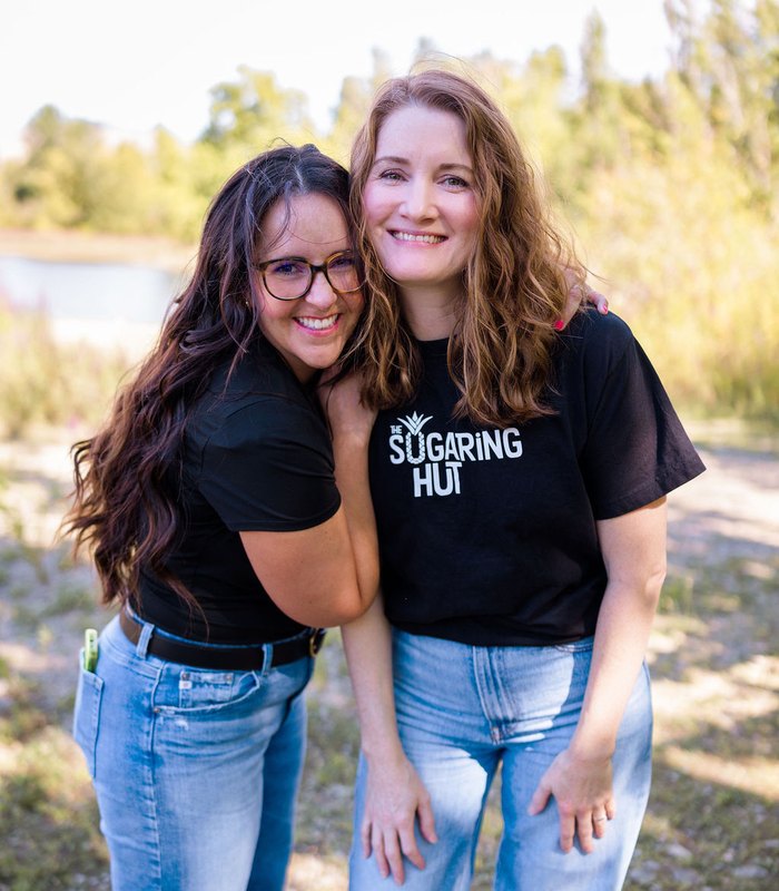 Two Sugaring Hut estheticians hugging outdoors