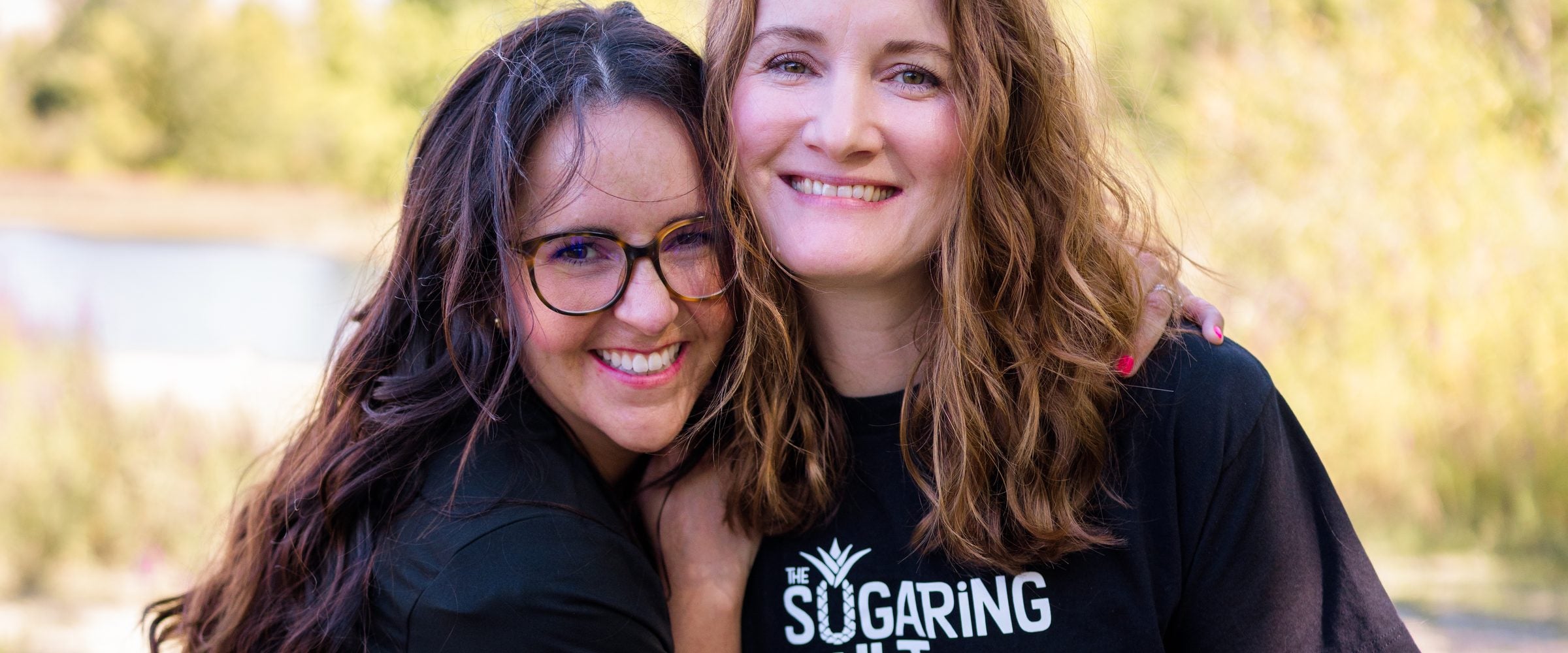 Two Sugaring Hut estheticians hugging outdoors